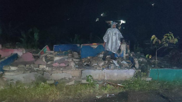 Petugas mengecek rumah ambruk.