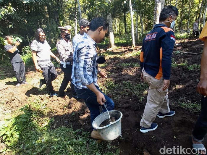Polisi mengamankan granat dengan menggunakan ember berisi pasir.