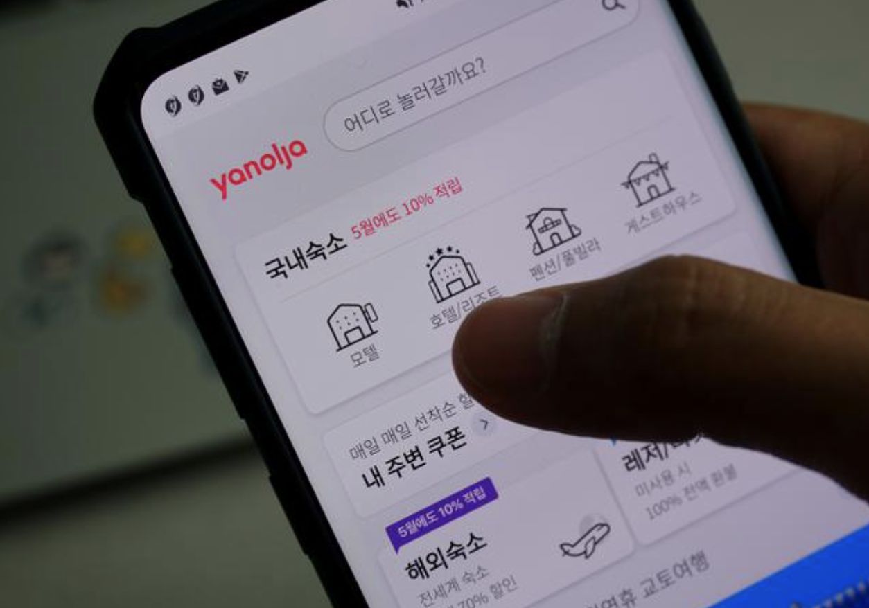 Sepasang kekasih melihat aplikasi pemesanan akomodasi Korea Selatan di ponsel selama kesempatan berfoto di Seoul, Korea Selatan. (REUTERS /Hyunyoung Yi)