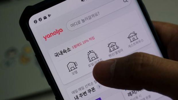 Sepasang kekasih melihat aplikasi pemesanan akomodasi Korea Selatan di ponsel selama kesempatan berfoto di Seoul, Korea Selatan. (REUTERS /Hyunyoung Yi)