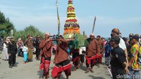 Sejumlah warga membawa gunungan yang berisi hasil pertanian dalam upacara adat Bekti Pertiwi Pisungsung Jaladri di Pantai Parangkusumo. Foto: Pradito Rida Pertana/detikJateng