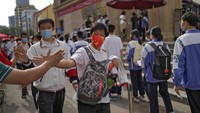 Seorang siswa saling memberi semangat dengan berjabat tangan. Ujian selama 2 hari ini dikenal sebagai Gaokao.