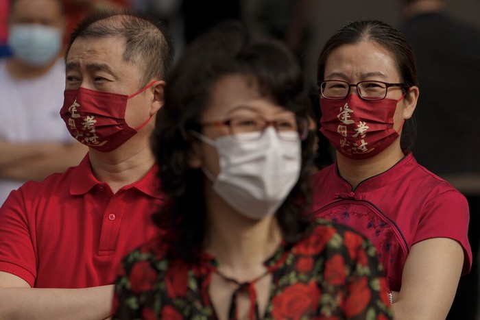 Virus Outbreak China College Entrance Exam A police officer stands watch as masked students line up to enter a school for the first day of China's national college entrance examinations, known as the gaokao, in Beijing, Tuesday, June 7, 2022. More than 11 million high school students throughout China will take the annual college entrance exams which started on Tuesday after the country has just overcome severe COVID-19 outbreaks in Shanghai and Beijing, according to state media. (AP Photo/Andy Wong)