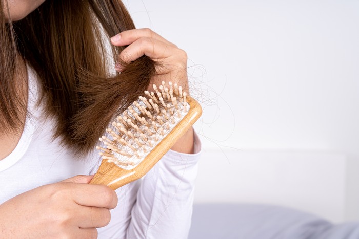 Comb with hair loss caused by stress or health problems, isolated photo on a white background.