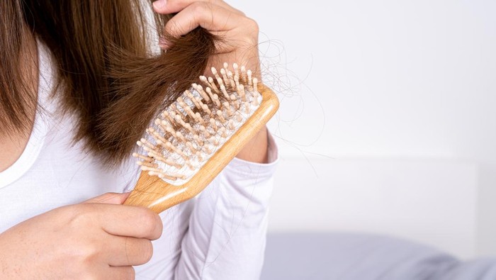 Comb with hair loss caused by stress or health problems, isolated photo on a white background.