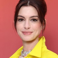 Anne Hathaway memilih riasan bergaya natural dengan nuansa nude peach. Sementara rambutnya disanggul tinggi, menyisakan poni panjang yang membingkai wajah cantiknya. Foto: Getty Images