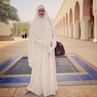 Selama berada di Tanah Suci, Donna Harun tampil anggun dengan memakai hijab syari bernuansa serba putih. Ia memakai khimar dari SiSeSa Indonesia.  Foto: Dok. Instagram @donnaharunofficial.