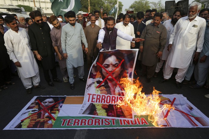 Members of a rickshaw drivers union burn a representation of an Indian national flag and pictures of Nupur Sharma, a spokesperson of the governing Hindu nationalist party, during a demonstration to condemn the derogatory references to Islam and the Prophet Muhammad made recently by Sharma, in Karachi, Pakistan, Tuesday, June 6, 2022. (AP Photo/K.M. Chaudary)