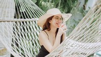 Bersantai dengan topi pantai di tepi kolam renang, Hana pilih jus buah sebagai aksesoris pelengkapnya untuk foto yang ia unggah ke Instagramnya. Foto: Instagram @hanaaaast