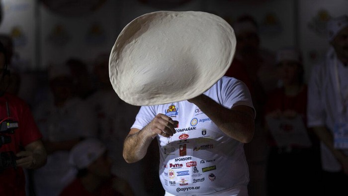 Melihat Aksi Para Koki di Kejuaraan Pizza Argentina A pizza master prepares dough during the Argentine Pizza Championship in Buenos Aires, Argentina, Tuesday, June 7, 2022. (AP Photo/Rodrigo Abd)