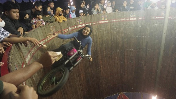 Pengendara sepeda motor perempuan Gita Selfira melakukan atraksi tong setan di Pasar Malam Alun-alun Kidul, Solo, Jawa Tengah, Selasa (7/6/2022).
