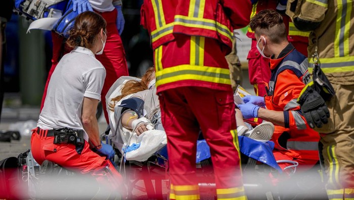 Mobil Tabrak Kerumunan Orang di Berlin, 1 Tewas Rescue workers help an injured person after a car crashed into a crowd of people in central Berlin, Germany, Wednesday, June 8, 2022. (AP Photo/Michael Sohn)