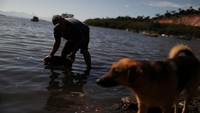 Marcelo da Silva (48) salah seorang nelayan yang ikut serta dalam proyek lingkungan tersebut mengumpulkan sampah televisi dari Teluk Guanabara di pantai Bancarios di Ilha do Governador, Rio de Janeiro, Brasil.  