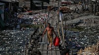 Seorang warga beraktivitas di area kampung nelayan yang dipenuhi sampah di kawasan Cilincing, Jakarta Utara, Rabu (8/6/2022). 