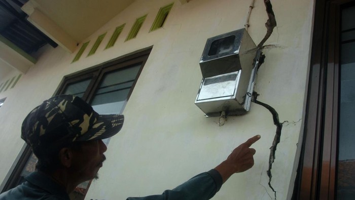 Warga menunjukkan tembok mushola yang retak akibat bencana tanah bergerak di Desa Kajen, Lebaksiu, Kabupaten Tegal, Jawa Tengah, Rabu (8/6/2022). Menurut pemerintah desa setempat, sebanyak 65 rumah rusak ringan dan tiga rumah rusak berat akibat bencana tanah bergerak dalam empat bulan terakhir. ANTARA FOTO/Oky Lukmansyah/rwa.