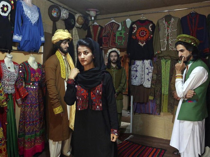 FILE - Ajmal Haqiqi, right, watches as Mahal Wak, center, practices modeling, in Kabul, Afghanistan, Aug. 3, 2017. The Taliban have detained a famous Afghan fashion model along with three colleagues, including Haqiqi, accusing them of disrespecting Islam and the Holy Quran. Haqiqi — known among Afghans for his fashion shows, You Tube clips, and modeling events — appeared handcuffed in videos posted to Twitter on Tuesday, June 7, 2022, by the Taliban’s General Directorate of Intelligence, DCI. (AP Photo/Rahmat Gul, File)