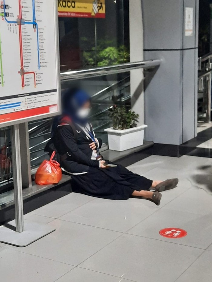Ibu hamil kelelahan usai menaiki tangga di Stasiun Cakung.
