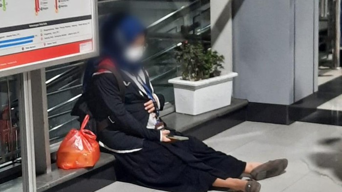 Ibu hamil kelelahan usai menaiki tangga di Stasiun Cakung.