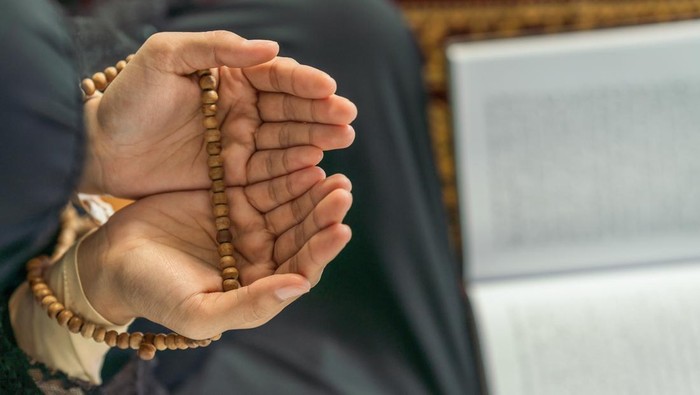 religious islamic background of hands of muslim prayer woman with prayer beads in dua praying for allah blessing in mosque