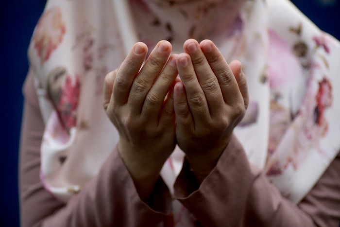 Asian muslim girl worried of her father being sick in hospital, she holds her fathers hand and pray for his health, family health insurance concept