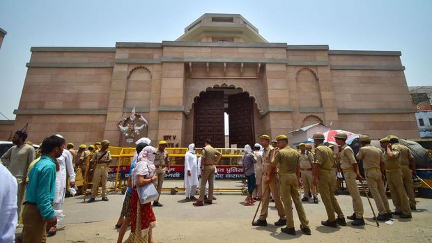 Policemen stand guard as Muslim devotees arrive to offer Friday noon prayer at the Gyanvapi mosque in Varanasi on May 20, 2022. - Last week reports claimed a leaked court-mandated survey of the centuries-old Gyanvapi mosque had discovered a shivalinga, a phallic representation of the Hindu god Shiva, at the site. (Photo by SANJAY KANOJIA / AFP) (Photo by SANJAY KANOJIA/AFP via Getty Images)