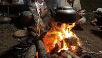 Irfan Hakim dan temannya tampak sedang menikmati masak di hutan. Mereka terlihat sedang merebus sesuatu di atas api unggun. Foto: Instagram @irfanhakim75