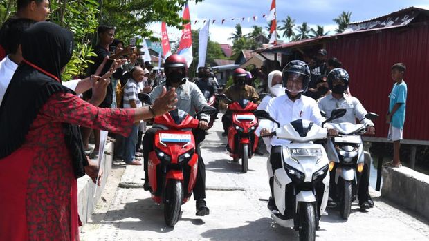 Jokowi dan Iriana berboncengan naik motor listrik di Kampung Mola, Sultra.