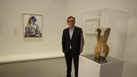 Kurator pameran sekaligus Wakil Direktur Musee National dart Moderne, Paris Didier Ottinger berpose di depan lukisan Picasso.  Foto: Getty Images for NGV/Kim Landy