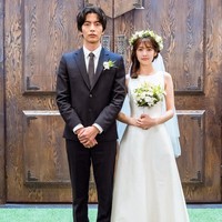 Meskipun terlihat canggung, pasangan drama Korea This Is My First Life membuat penonton baper dengan adegan pernikahannya. Sang aktor, Lee Min Ki memakai setelan jas hitam sederhana. Sedangkan Jung So Min memakai sleeveless dress putih sambil memegang buket bunga, yang serasi dengan flower crown-nya. Foto: dok. tvN