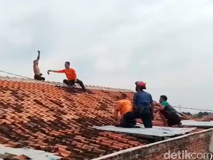 Proses evakuasi seorang pria yang nekat memanjat atap gedung lantai dua di Kota Pekalongan oleh petugas Damkar dan BPBD, Kamis (9/6/2022).