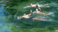 Sejumlah remaja berenang saat merayakan hari terakhir sekolah di Rieti, Italia.