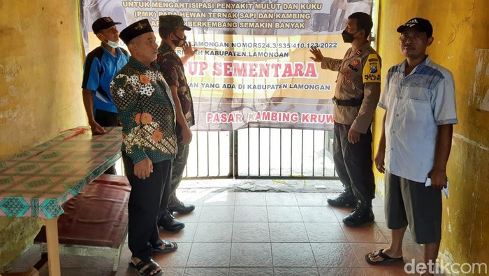 Sejumlah petugas gabungan memastikan tidak ada jual beli di Pasar Hewan Lamongan