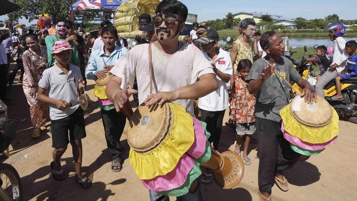 Local villagers march in a ceremony to invoke rain amid the rice planting season in Pring Ka-ek village, northwest of Phnom Penh, Cambodia, Thursday, June 9, 2022. Local residents Thursday held the annual Buddhist ceremony to pray for the rain to grow rice as their main crop. (AP Photo/Heng Sinith)