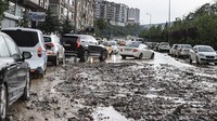 Lumpur yang menumpuk membuat para pengendara sulit untuk melintasi jalan.  