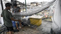 Sejumlah nelayan memperbaiki jaring ikan yang rusak di kawasan Kalibaru, Cilincing, Jakarta Utara, Rabu (8/6/2022). (Risyal Hidayat/Antara Foto).
