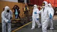 Mentan memakai baju hazmat dan disemprot disinfektan sebelum naik ke kapal.