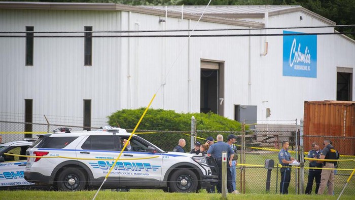 Law enforcement officials stand near the scene of a shooting at Columbia Machine, Inc., in Smithsburg, Md., Thursday, Jan. 9, 2022. (Bill Green/The Frederick News-Post via AP)