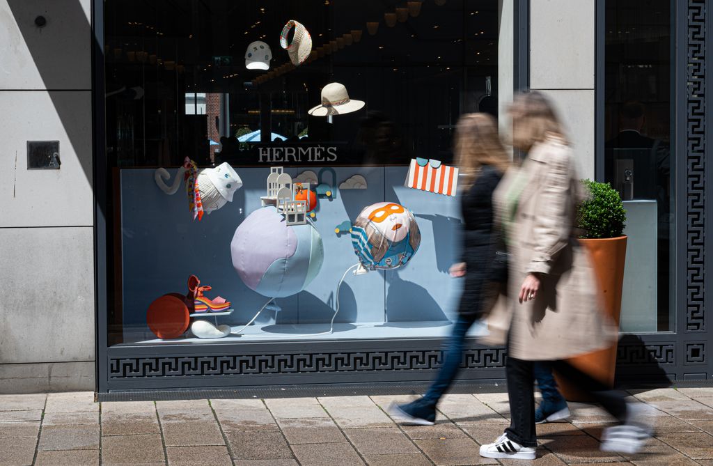 PRODUCTION - 27 May 2022, Hamburg: Two young women walk past a boutique of the fashion company Hermès. Luxury fashion has long since ceased to be aimed only at wealthy people. Among the younger generation, expensive luxury brands are becoming increasingly popular. (to dpa 