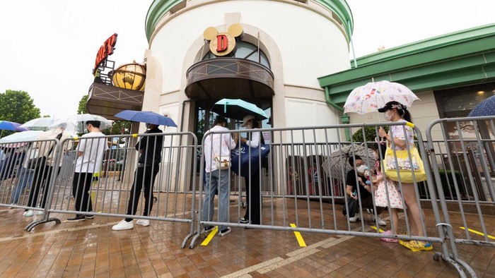 SHANGHAI, CHINA - JUNE 10: Visitors walk the grounds at Shanghai Disney Resort on June 10, 2022 in Shanghai, China. Shanghai Disney Resort is resuming partial operations, with reduced capacity and opening hours, as COVID-19 cases ease in the city. (Photo by Hu Chengwei/Getty Images)