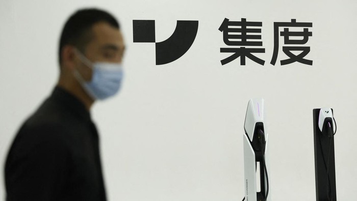 Staff members stand near ROBO-01, a 