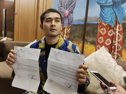 Karmel Nikcolas menunjukkan bukti telah membuat laporan polisi.