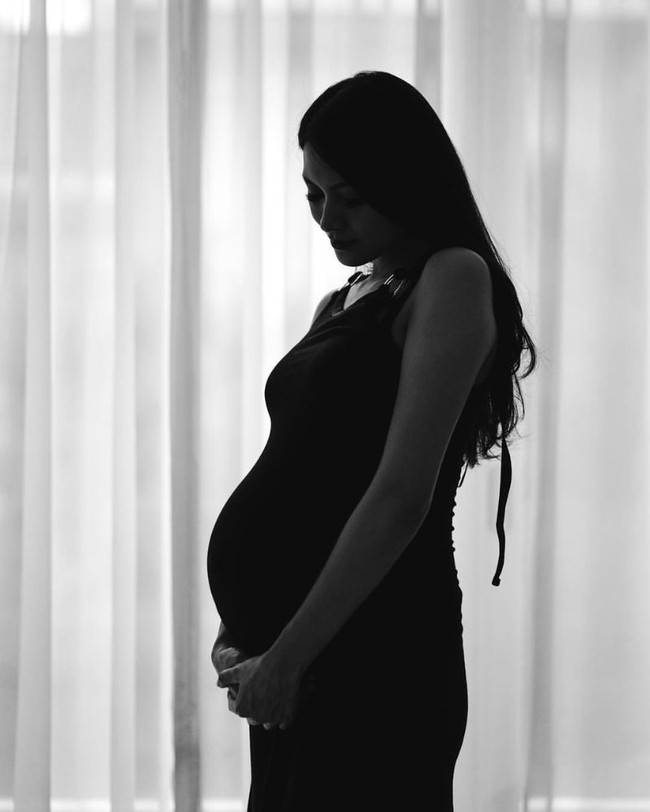 Selanjutnya ada penampilan simpel dari Donita saat melakukan pemotretan maternity. Hanya dengan mengenakan dress polos tanpa lengan dan berpose di depan jendela rumah sambil melihat ke arah baby bump, hasil foto maternity hitam putih Donita terlihat menawan. Foto: Instagram