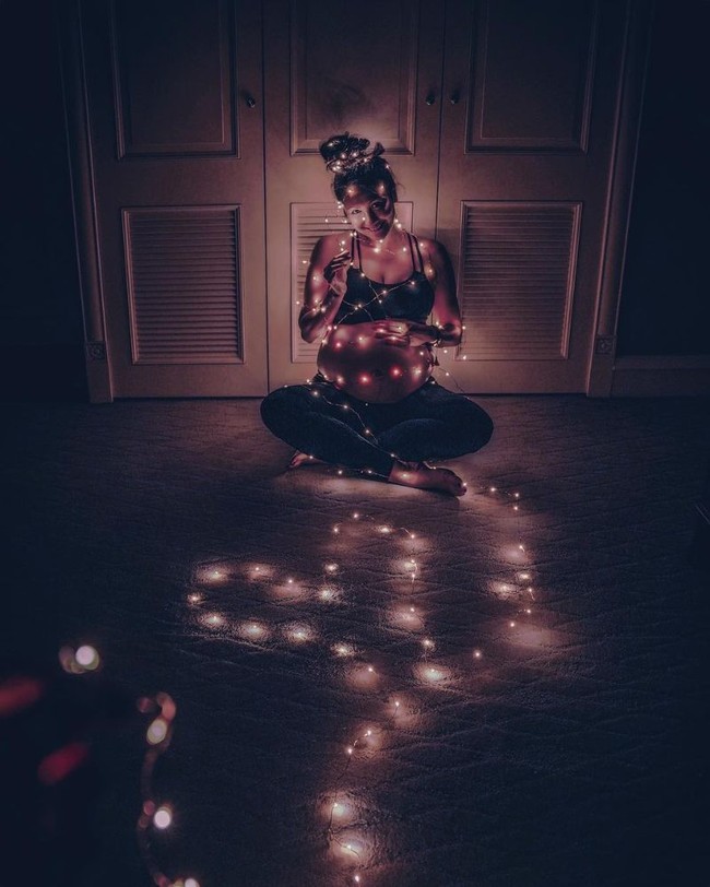 Dilakukan di rumah dengan mengenakan properti sederhana berupa lampu-lampu kecil, gaya foto maternity Sharena Delon terlihat unik sekaligus keren. Pakaian yang dikenakan Sharena dalam foto juga tampak simpel, hanya mengenakan celana panjang legging dan sport bra. Foto: Instagram