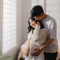 Potret maternity Rinni Wulandari bersama sang suami, Jevin Julian tampak simpel dengan kompak mengenakan pakaian berwarna putih. Keduanya terlihat berpose romantis sambil memperlihatkan baby bump di perut Rinni yang sudah cukup besar. Foto: Instagram