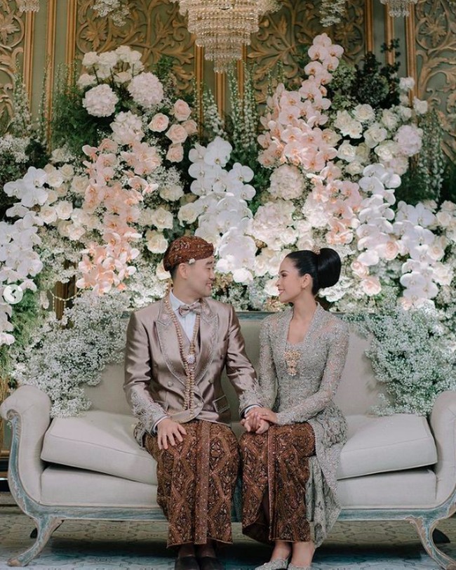 Setelah prosesi akad nikah, keduanya berganti busana. Masih menggunakan pakaian adat Jawa, Jesse Choi menggunakan blankon dan kain batik. Untuk atasannya Jesse menggunakan jas bernuansa pastel silver. Sementara Maudy menggunakan kebaya bernuansa hijau. Foto: dok. Instagram/@maudyayunda