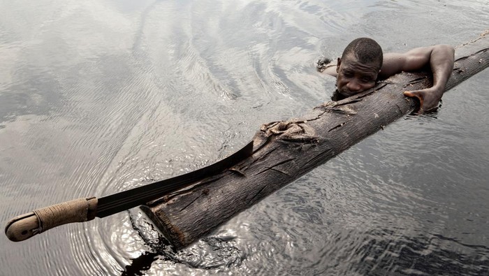 Potret Ironi Hutan Nigeria, Jumlah Penebang Melebihi Jumlah Pohon Logger, Komiyo Ikuejamoye, fells a tree with a chainsaw in Ipare, Ondo State, Nigeria, March 22, 2021. Picture taken March 22, 2021. REUTERS/Nyancho NwaNri SEARCH