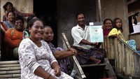 Warga Desa Mola Samaturu, Usri (tengah) bersama keluarganya menunjukkan sertifikat tanah gratis yang diberikan Presiden Joko Widodo di Kecamatan Wangi Wangi Selatan, Wakatobi, Sulawesi Tenggara, Kamis (9/6/2022).   