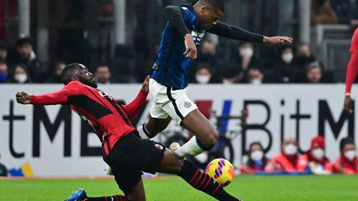 AC Milans English defender Fikayo Tomori (L) tackles Inter Milans Dutch defender Denzel Dumfries during the Italian Cup (Coppa Italia) semi-final first leg football match AC Milan vs Inter Milan at the Giuseppe Meazza Stadium (also called San Siro), in Milan on March 1, 2022. (Photo by MIGUEL MEDINA / AFP) (Photo by MIGUEL MEDINA/AFP via Getty Images)
