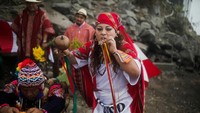 Foto tim Australia yang lebih kecil ditusuk dengan pedang pendek saat salah satu dukun pribumi sembari meniup alat musik tradisional yang dikenal sebagai pututo atau caracola.