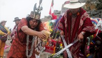 Para dukun yang mengenakan jubah Andes warna-warni terlihat melakukan upacara di lereng bukit di Lima.